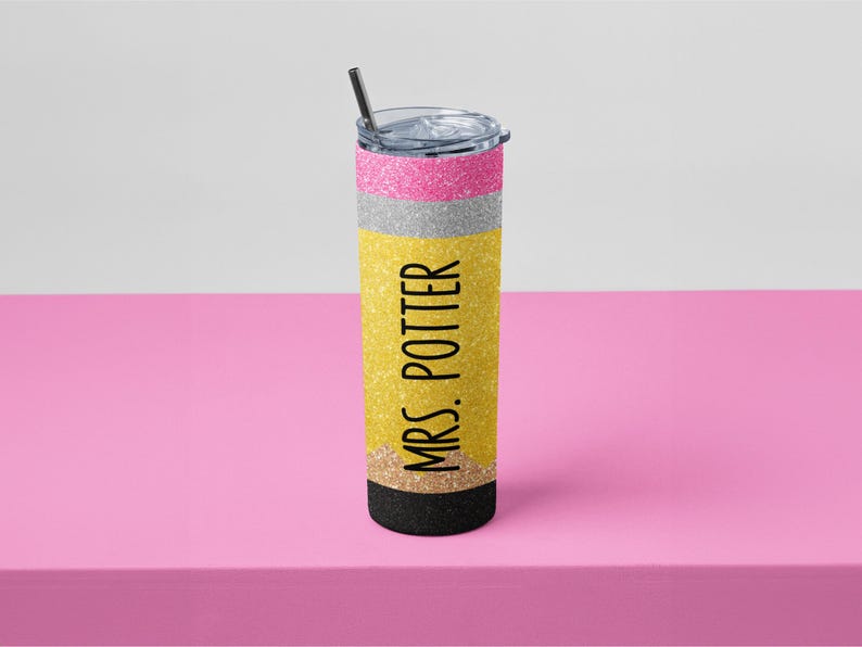 May include: A glittery pencil-themed tumbler with a black straw. The tumbler has pink, silver, and yellow sections, with "MRS. POTTER" printed vertically in black. The bottom is black.