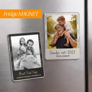 May include: Two rectangular fridge magnets with family photos. One magnet has the text "Best Dad Ever" and names. The other magnet says "Grandpa est. 2022". Both magnets have a black border and film strip design.