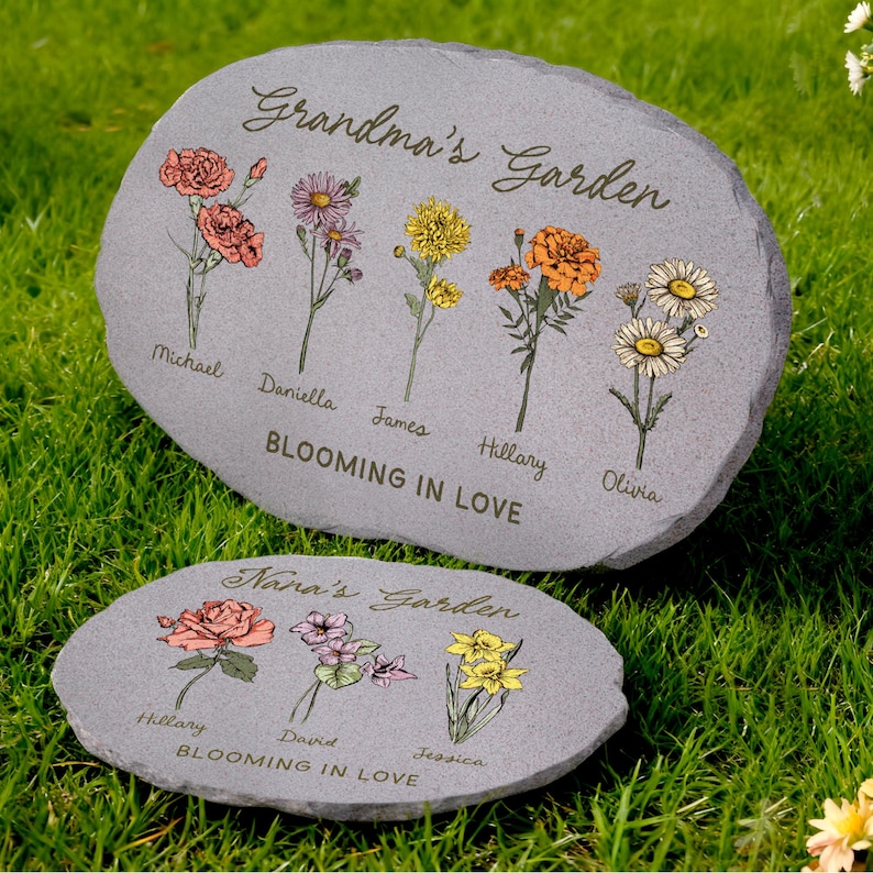 May include: Two gray stone garden markers with floral designs and names. The larger stone reads "Grandma's Garden" and features illustrations of flowers with names like Michael and Olivia. The smaller stone says "Nana's Garden" with names like Hillary and Jessica.