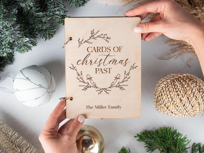 May include: A wooden book with a floral design and the text "Cards of Christmas Past" and "The Miller Family".