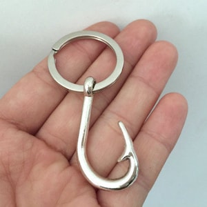 Puede incluir: Llavero de plata con un gancho en forma de anzuelo.