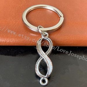 Op de afbeelding: Zilveren sleutelhanger met een oneindigheidssymbool en een zilveren sleutelring. Het oneindigheidssymbool is een populair symbool voor eeuwige liefde en vriendschap.