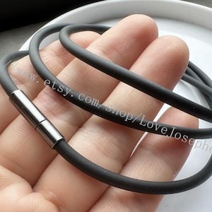 May include: A dark gray bracelet with a magnetic clasp. The bracelet is made of a flexible, rubber-like material. The clasp is silver-colored. The Etsy shop name, LoveJosephdesign, is visible on the bracelet.