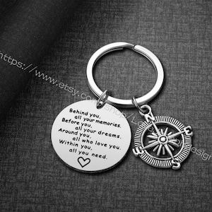May include: Silver keychain with a compass charm and a round tag that reads "Behind you, all your memories. Before you, all your dreams. Around you, all who love you. Within you, all you need."
