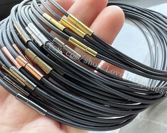 May include: A stack of black elastic choker necklaces with gold, silver, and rose gold clasps.