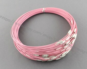 May include: A close-up of a pink wire choker necklace with silver clasps. The necklace is made of multiple strands of thin wire, creating a delicate and layered look.