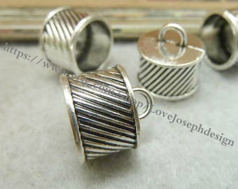 May include: Silver metal end caps with a decorative grooved design. Some of the end caps have a loop on top.