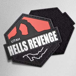May include: Black and red patch with the text "UTAH HELLS REVENGE" and a white topographic map design. The patch has a black border and a hook-and-loop backing for attachment.