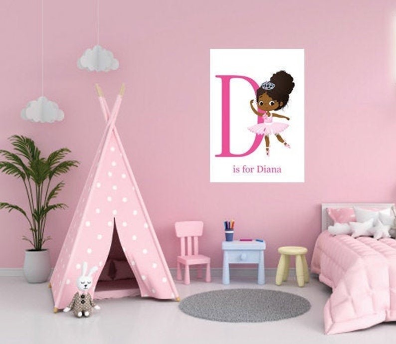 Puede incluir: Una tienda de campa&ntilde;a tipi de lunares rosa y blancos con un conejito de peluche en su interior. Un p&oacute;ster rosa y blanco con una ni&ntilde;a bailarina de dibujos animados y la letra D est&aacute; en la pared. El p&oacute;ster dice "D is for Diana".
