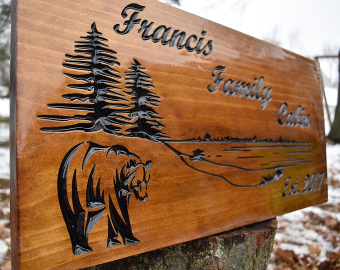 Enjoy the best longest lasting work of art. Wood carved sign with scenic images of bear pine trees and lake. Include your family name est.