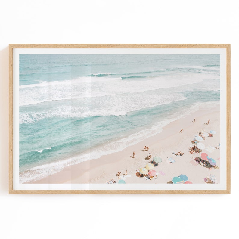 May include: An aerial view of a beach with turquoise water and white sand. People are relaxing under colorful umbrellas.