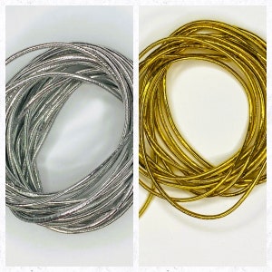 May include: Two spools of metallic cord, one silver and one gold. The cord is thin and has a slight sheen.