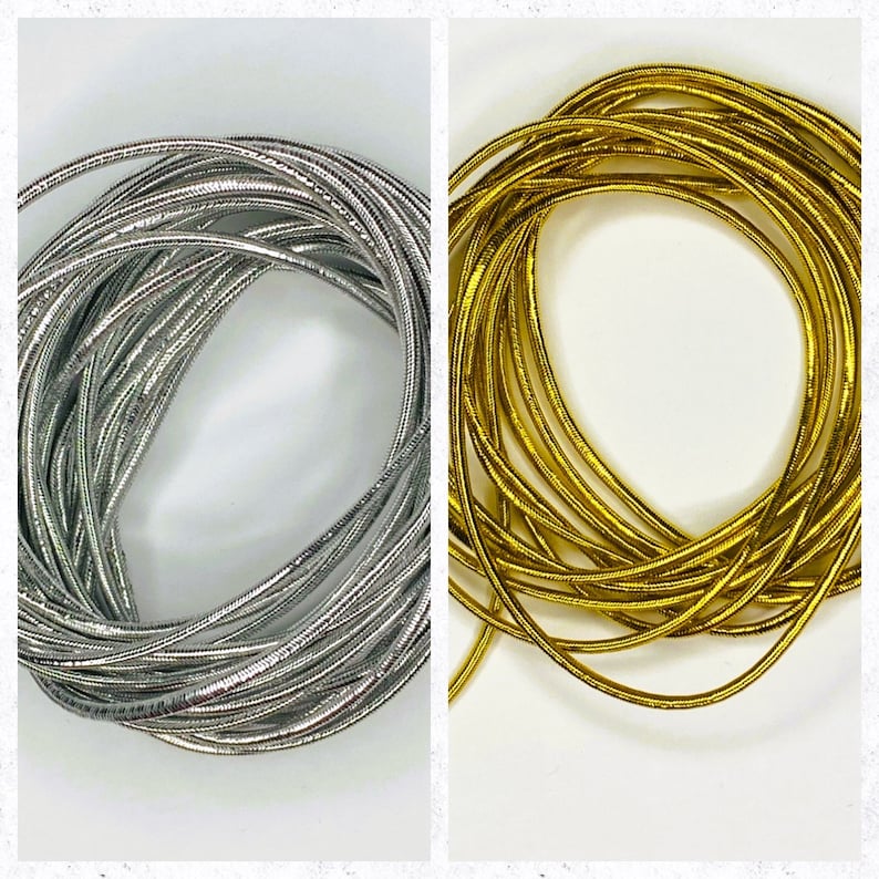 May include: Two spools of metallic cord, one silver and one gold. The cord is thin and has a slight sheen.