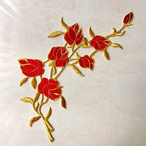 May include: Red embroidered rose flower applique with gold thread detailing. The applique features a cluster of roses with leaves and stems.