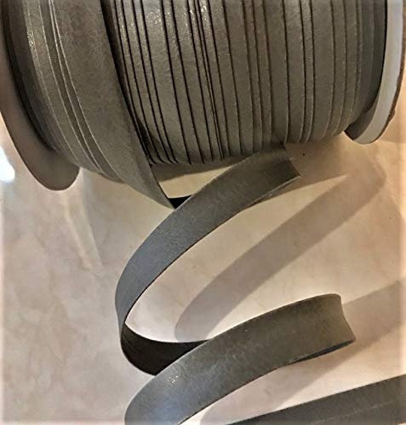 May include: A spool of gray leather cord, wound tightly and ready to be used for crafting projects. The cord is smooth and has a subtle sheen.
