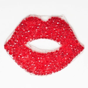 May include: A red lip-shaped patch covered in small red rhinestones.