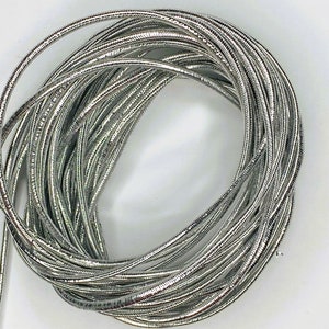 May include: A coil of silver metallic cord, perfect for crafting jewelry or adding a touch of sparkle to projects.