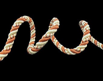 May include: A close-up of a twisted rope trim with alternating stripes of white and orange.