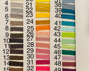 May include: A colour chart displaying 51 herringbone ribbon samples in diverse shades. The ribbon swatches are numbered 1 to 51, showcasing a spectrum of colours from neutral tones to pastels and bright hues. Suitable for craft projects.