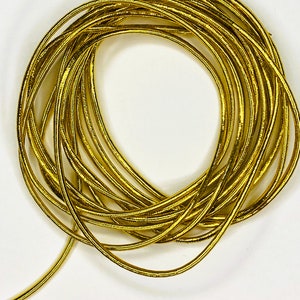 May include: A coil of gold-colored elastic cord. The cord is thin and has a slightly textured surface.