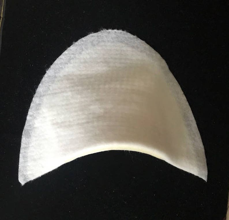 May include: White felt shoe insert with a curved shape.