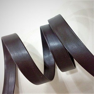 May include: A close-up of a dark brown leather trim, showing the texture and the way it bends.