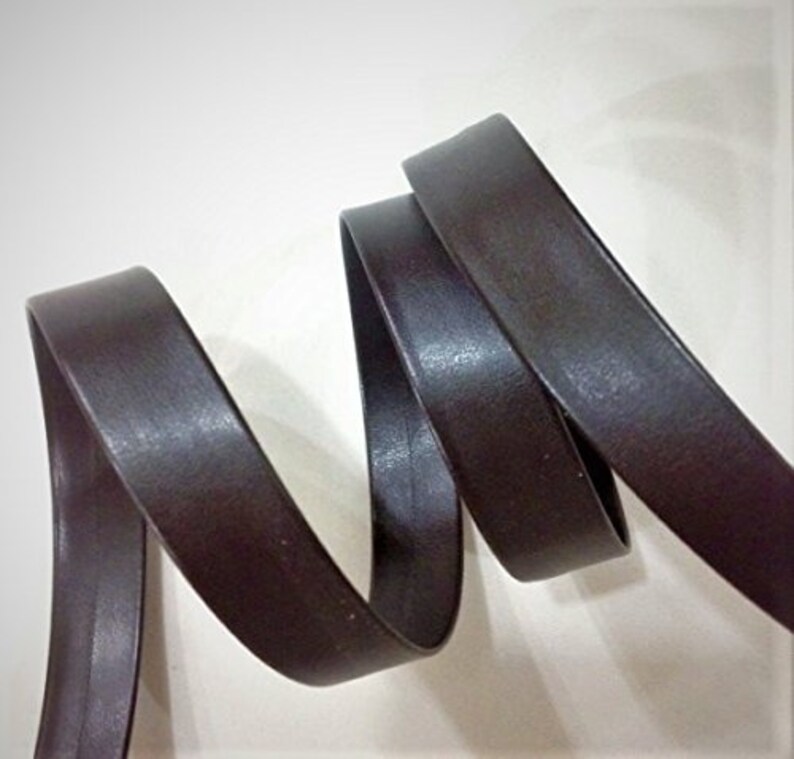 May include: A close-up of a dark brown leather trim, showing the texture and the way it bends.