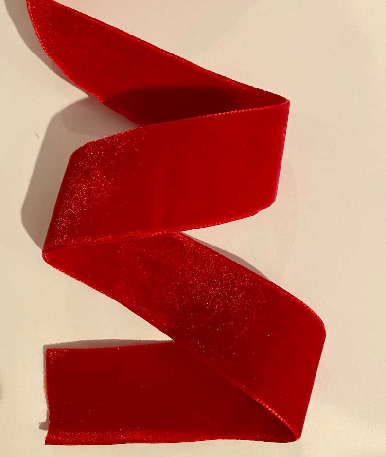 Puede incluir: Un rollo de cinta de terciopelo rojo. La cinta es suave y lujosa, perfecta para agregar un toque de elegancia a cualquier proyecto.