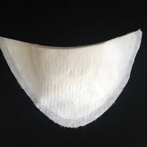 May include: White fabric shoe insert with a curved shape.
