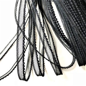 Könnte beinhalten: Schwarzes Netz-Zierband mit gewelltem Rand. Das Band ist dünn und zart und perfekt, um jedem Projekt einen Hauch von Eleganz zu verleihen.