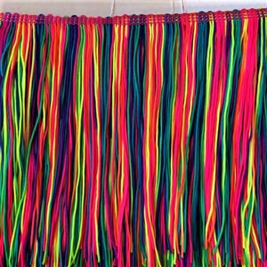 以下が含まれることがあります： ピンク、グリーン、イエロー、ブルー、パープルなど、さまざまな明るい色が組み合わされたマルチカラーのフリンジトリム。フリンジは細い糸でできており、幅は約1インチです。