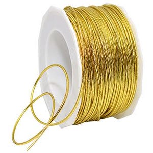 May include: A spool of gold metallic cord, perfect for crafting and decorating. The cord is wound tightly on a white plastic spool.