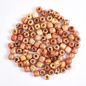 May include: A large group of wooden beads with various patterns and designs. The beads are brown and beige with red accents. The beads are all about the same size and are arranged in a loose pile.