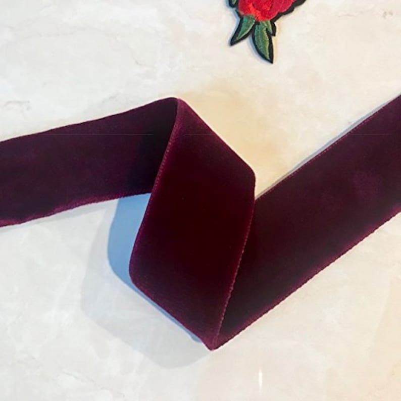 Puede incluir: Un rollo de cinta de terciopelo burdeos oscuro. La cinta es suave y lujosa, perfecta para agregar un toque de elegancia a cualquier proyecto.