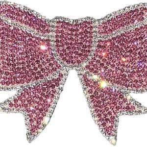 May include: A pink rhinestone bow with a sparkly finish.