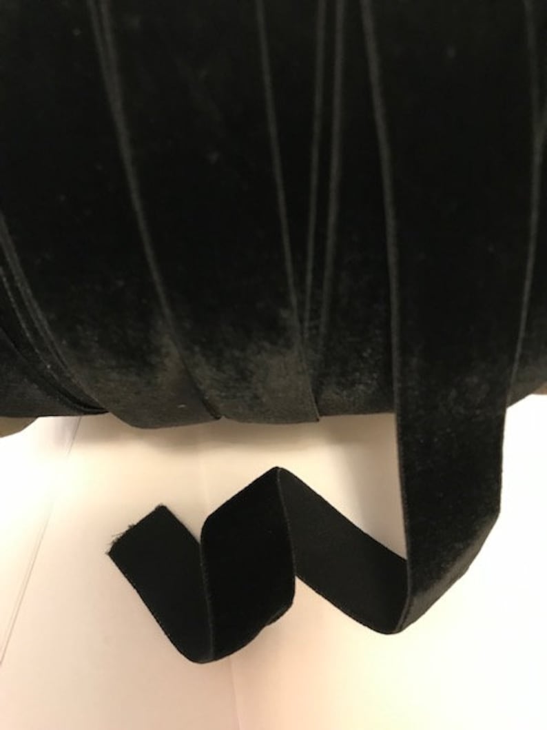 Pu&ograve; includere: Un rotolo di nastro di velluto nero. Il nastro &egrave; largo circa 2,5 cm ed &egrave; mostrato in primo piano.