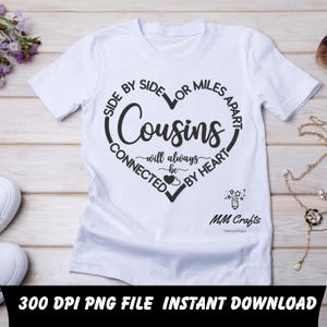 May include: White t-shirt with a black heart-shaped graphic that reads "Cousins will always be connected by heart." The text "Side by side or miles apart" surrounds the heart. The shirt also has the text "MM Crafts Making Magic."