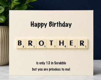 May include: A cream-colored greeting card with the text Happy Birthday at the top. The word BROTHER is spelled out using seven beige Scrabble tiles. Below the tiles, the text reads is only 12 in Scrabble but you are priceless to me!
