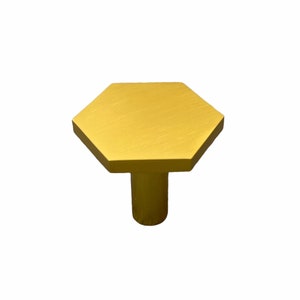 May include: A gold hexagonal cabinet knob with a brushed finish.