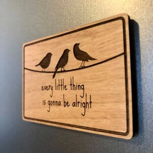 Puede incluir: Un letrero de madera con tres p&aacute;jaros posados en un alambre, y el texto "every little thing is gonna be alright".