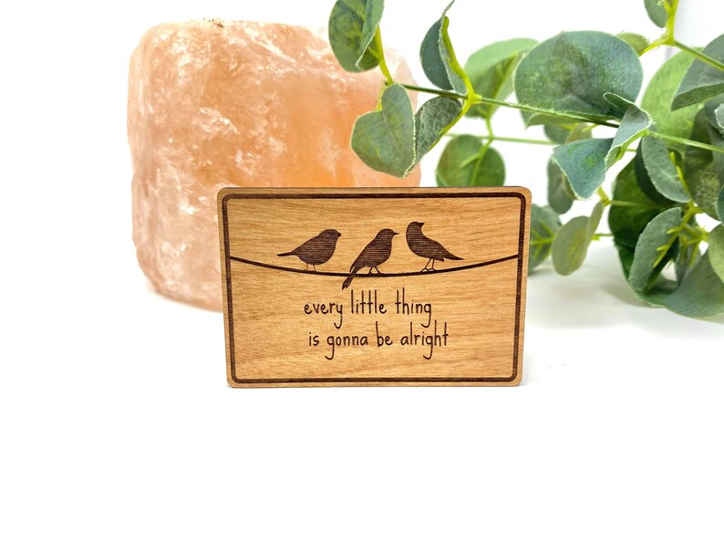 Puede incluir: Un letrero de madera con tres p&aacute;jaros posados en un alambre. El letrero dice "every little thing is gonna be alright".
