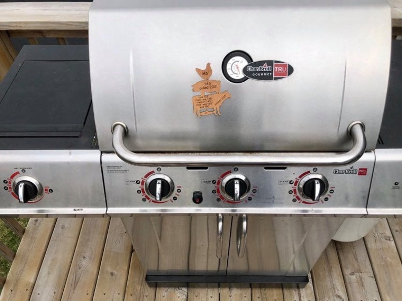 May include: A stainless steel Char-Broil TRU Infrared gas grill with four burners and a side burner. The grill has a black lid with a thermometer and a Char-Broil TRU Infrared Gourmet logo.