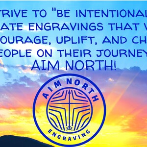 May include: A blue and white logo with the text "AIM NORTH" and "ENGRAVING" against a colorful sunset sky. The text reads "We strive to "be intentional" and create engravings that will encourage, uplift, and cheer people on their journey! Aim North!"