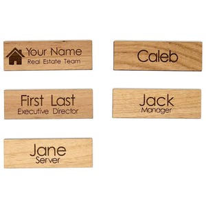 Puede incluir: Cinco placas de identificación rectangulares de madera con texto grabado con láser. Las placas muestran varios nombres y títulos, incluidos Your Name Real Estate Team, Caleb, First Last Executive Director, Jack Manager y Jane Server, con un icono de casa.