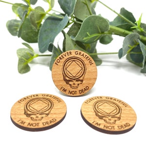 May include: Three wooden round ornaments with the text "Forever Grateful I'm Not Dead" and a skull with a diamond shape inside.