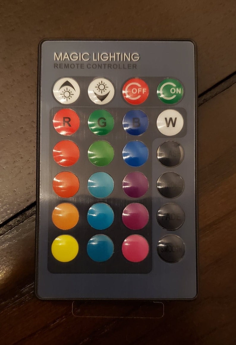 May include: A remote control for magic lighting with buttons for on, off, fade, smooth, red, green, blue, white, and various color options.