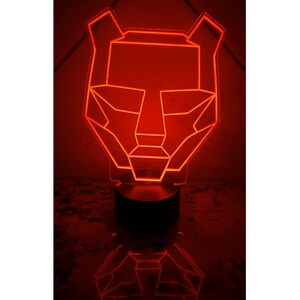 May include: A red geometric animal head shaped night light with a black base.