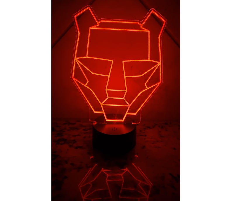 May include: A red geometric animal head shaped night light with a black base.