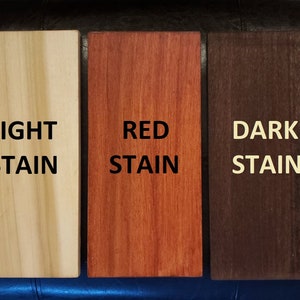 Puede incluir: Tres muestras de madera que muestran diferentes colores de tinte: claro, rojo y oscuro. Las muestras est&aacute;n etiquetadas con el color del tinte.