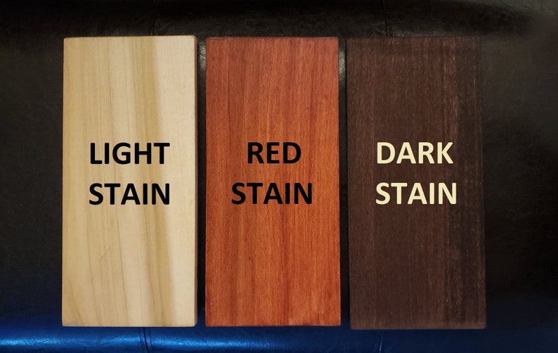 Puede incluir: Tres muestras de madera que muestran diferentes colores de tinte: claro, rojo y oscuro. Las muestras est&aacute;n etiquetadas con el color del tinte.